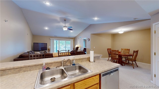 kitchen with sink, vaulted ceiling, stainless steel dishwasher, ceiling fan, and light colored carpet