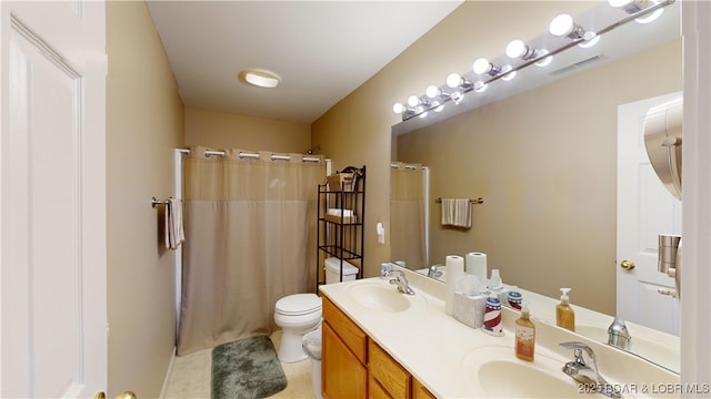 bathroom with tile patterned floors, curtained shower, vanity, and toilet