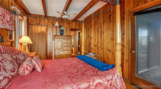 bedroom with ceiling fan and wooden walls