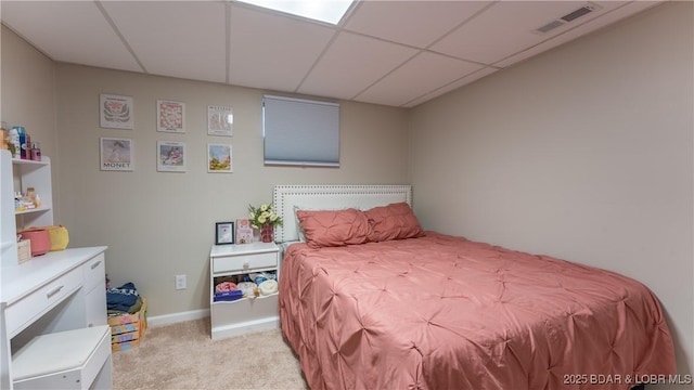 bedroom with a paneled ceiling and light colored carpet