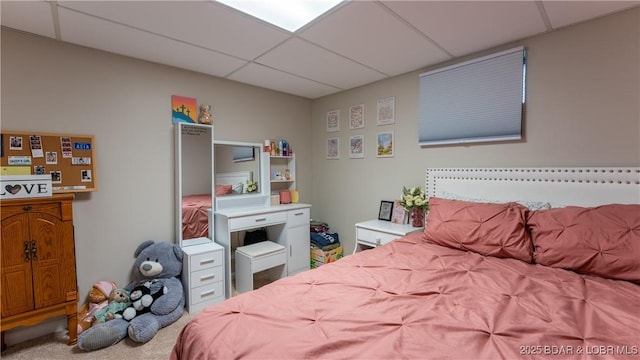 bedroom with carpet flooring and a drop ceiling