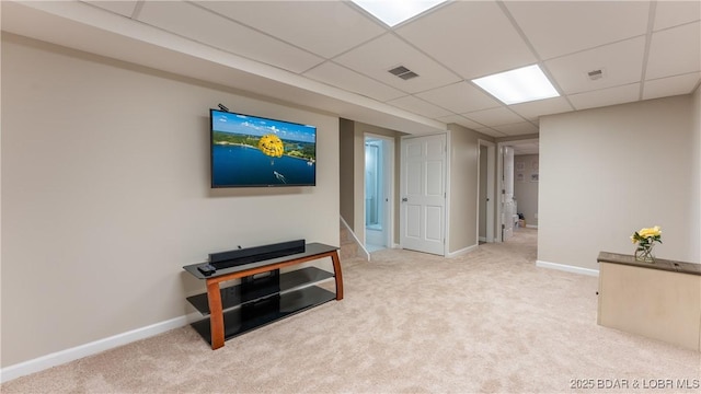 interior space with a paneled ceiling and light carpet