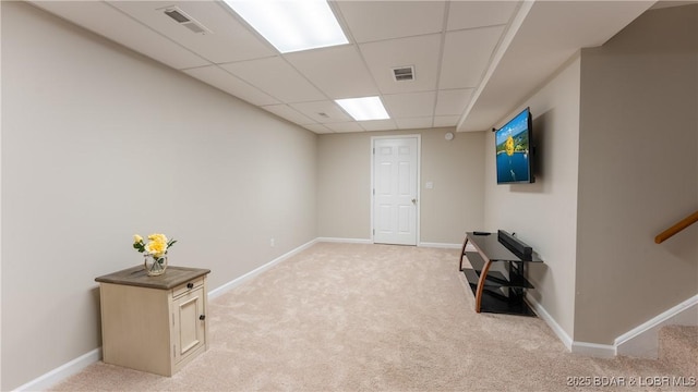 basement with a drop ceiling and light colored carpet