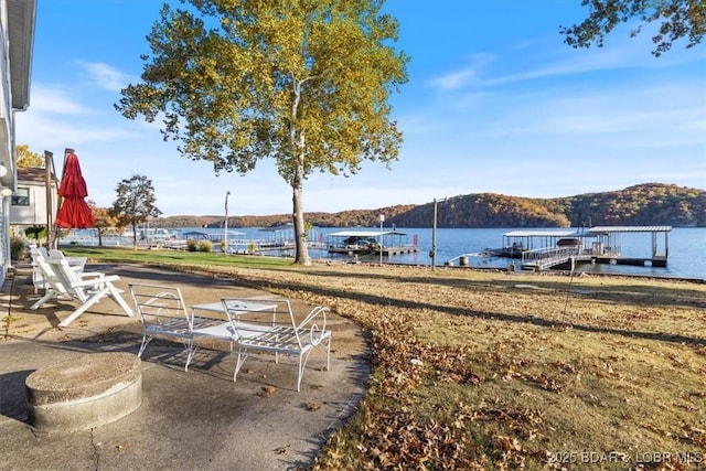 view of yard featuring a dock and a water and mountain view