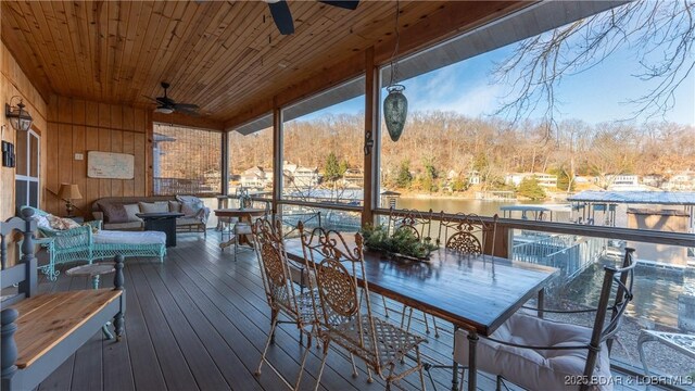 deck featuring an outdoor living space, a water view, and ceiling fan