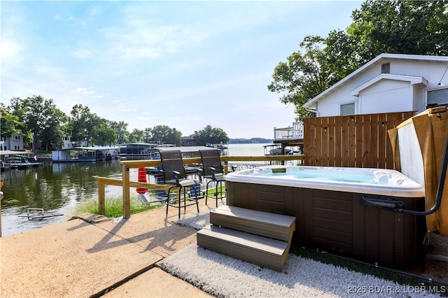 view of patio / terrace with a hot tub and a water view