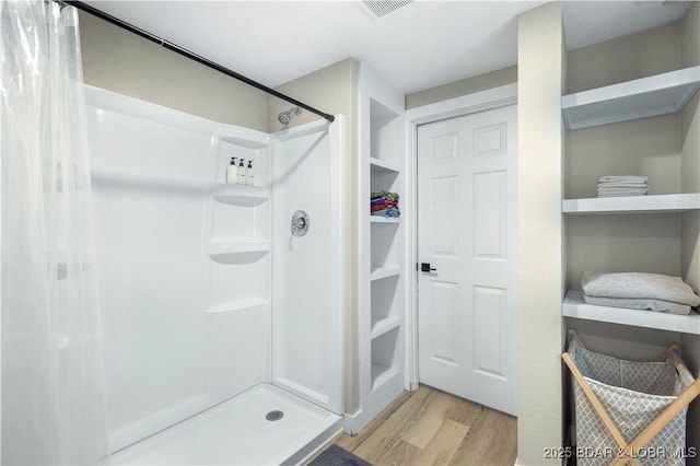 bathroom with wood-type flooring and a shower with curtain