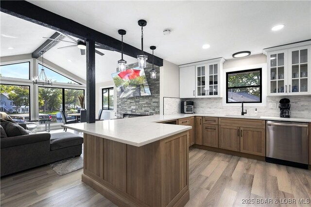 kitchen featuring pendant lighting, dishwasher, vaulted ceiling with beams, tasteful backsplash, and white cabinetry