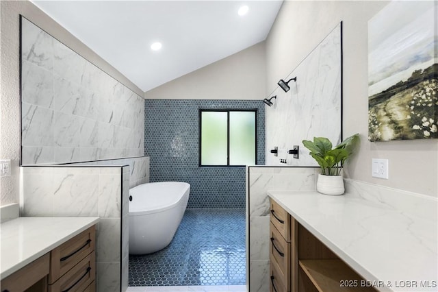 bathroom featuring lofted ceiling, shower with separate bathtub, tile walls, vanity, and tile patterned flooring