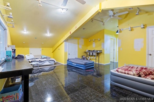 interior space featuring vaulted ceiling, granite finish floor, a ceiling fan, and baseboards