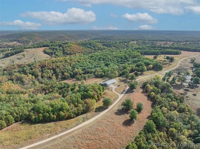 birds eye view of property featuring a view of trees