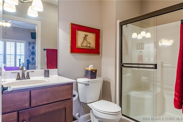 bathroom featuring ceiling fan, toilet, vanity, and walk in shower