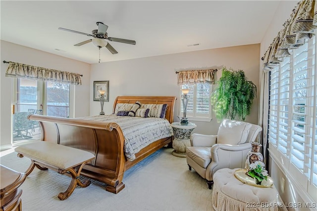 carpeted bedroom with ceiling fan and multiple windows