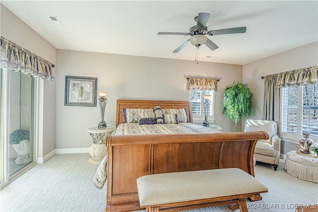 carpeted bedroom featuring multiple windows and ceiling fan