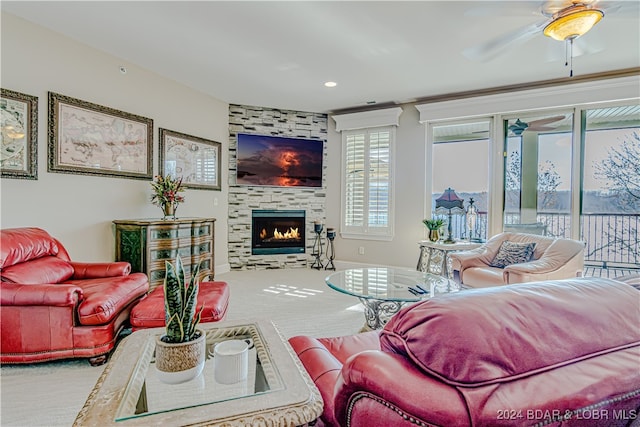 carpeted living room featuring a tile fireplace and ceiling fan