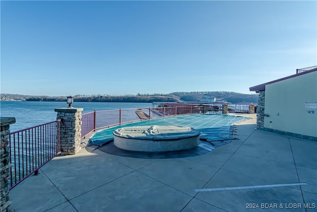 view of pool with a patio and a water view