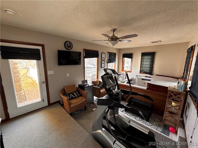 office space with carpet floors, visible vents, a ceiling fan, a textured ceiling, and baseboards