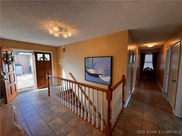 foyer with a textured ceiling and baseboards