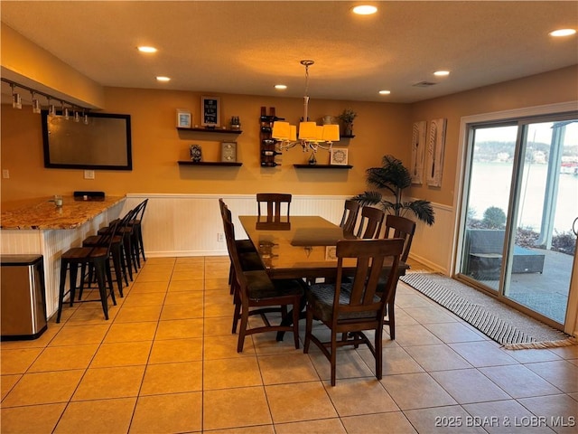 dining space with recessed lighting, a wainscoted wall, and light tile patterned floors