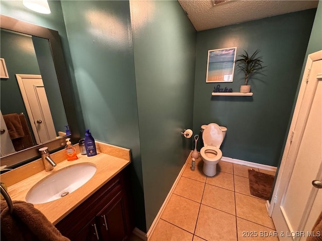 bathroom with baseboards, toilet, tile patterned flooring, a textured ceiling, and vanity