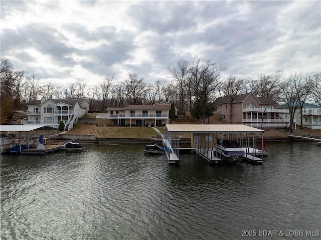 dock area featuring a water view, boat lift, and a residential view