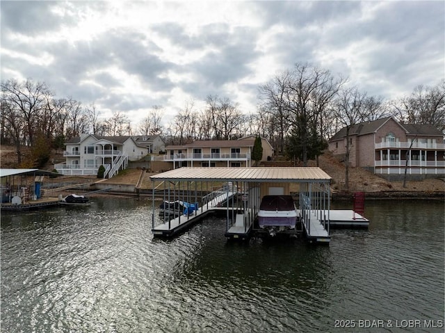 view of dock with a water view, boat lift, and a residential view