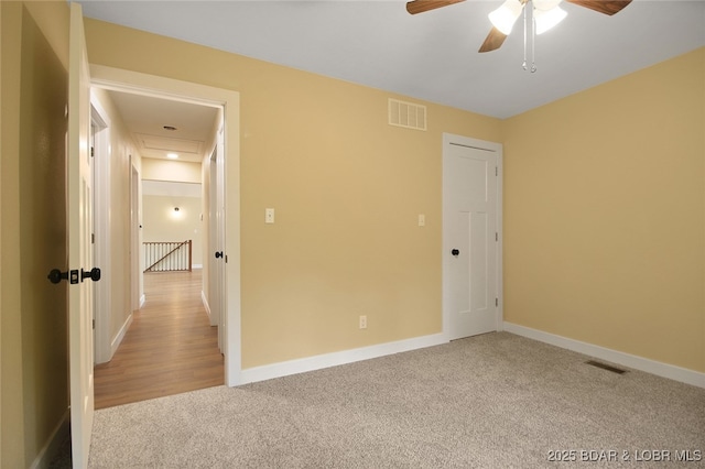 carpeted spare room with ceiling fan