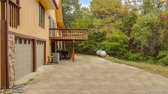 view of patio / terrace with cooling unit, a garage, and a deck