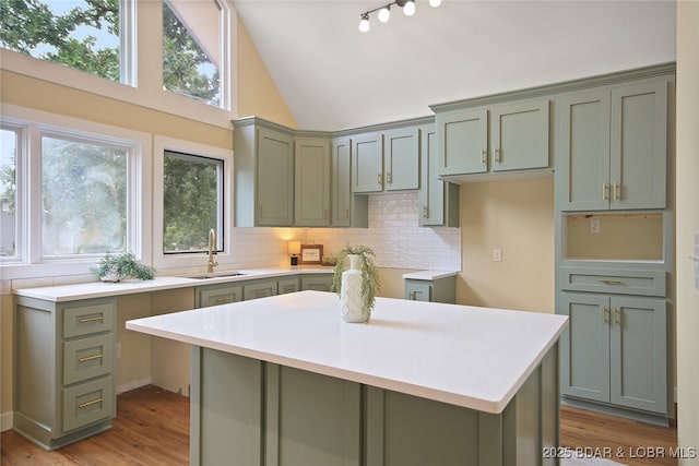 kitchen featuring a center island, light hardwood / wood-style flooring, sink, and tasteful backsplash