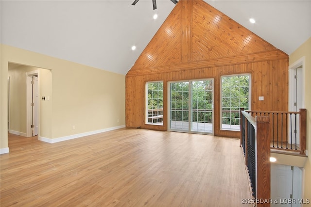 unfurnished living room with a wealth of natural light, ceiling fan, high vaulted ceiling, and light wood-type flooring