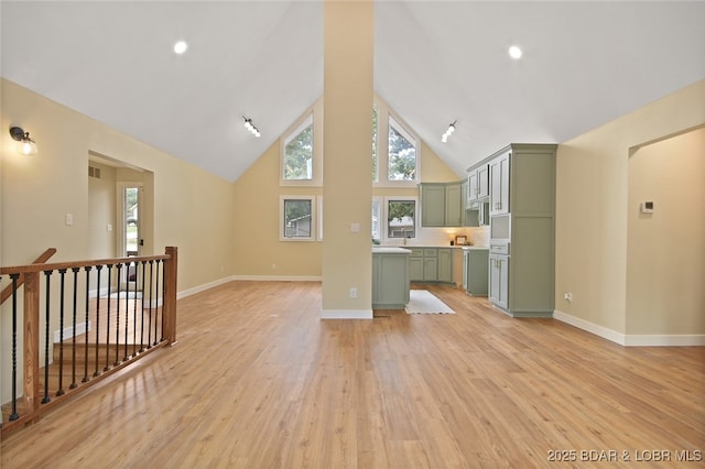 unfurnished living room featuring high vaulted ceiling and light hardwood / wood-style floors