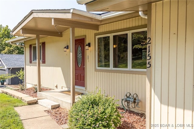 view of exterior entry featuring covered porch