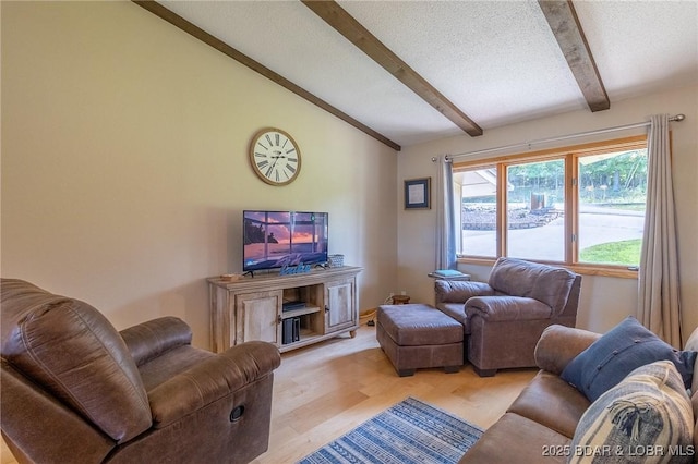 living room featuring vaulted ceiling with beams, light hardwood / wood-style floors, and a textured ceiling