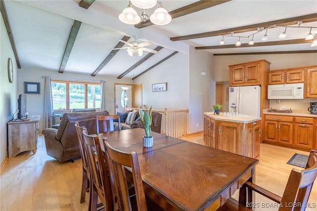 dining space featuring vaulted ceiling with beams, light hardwood / wood-style flooring, and ceiling fan with notable chandelier