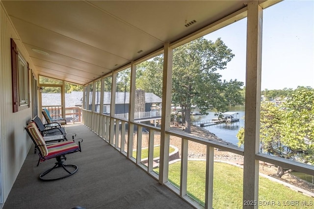 sunroom featuring a water view and lofted ceiling