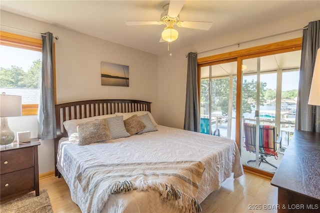 bedroom featuring ceiling fan, light hardwood / wood-style floors, access to exterior, and multiple windows