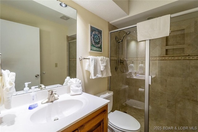 bathroom featuring vanity, toilet, and a shower with shower door