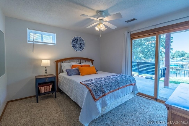 carpeted bedroom with access to exterior, a textured ceiling, and ceiling fan