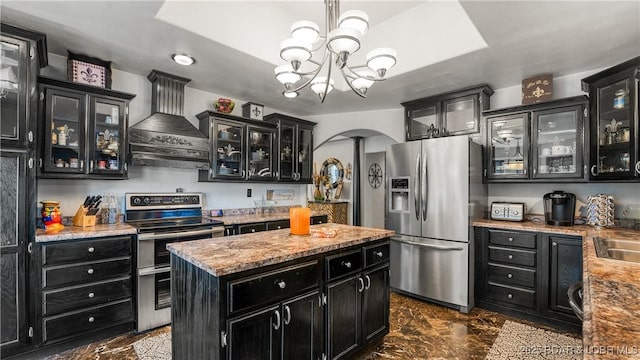 kitchen with hanging light fixtures, stainless steel appliances, a notable chandelier, a kitchen island, and custom exhaust hood