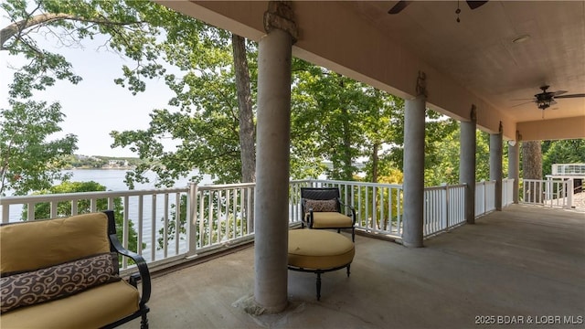 view of patio with a water view and ceiling fan