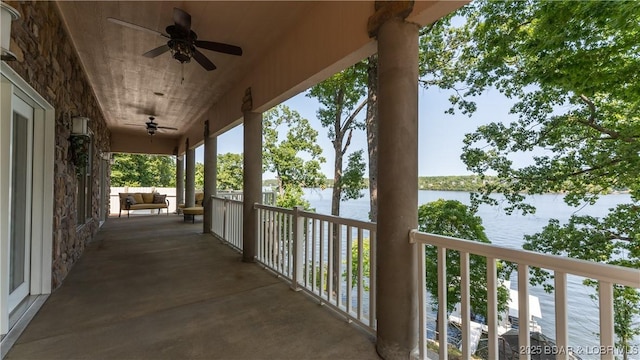 balcony featuring a water view and ceiling fan