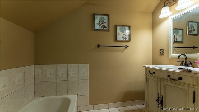 bathroom featuring tile patterned flooring, a bath, vanity, and lofted ceiling