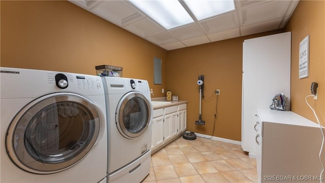 laundry area featuring washer and clothes dryer, cabinets, and light tile patterned floors