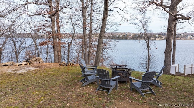 view of yard featuring a fire pit and a water view