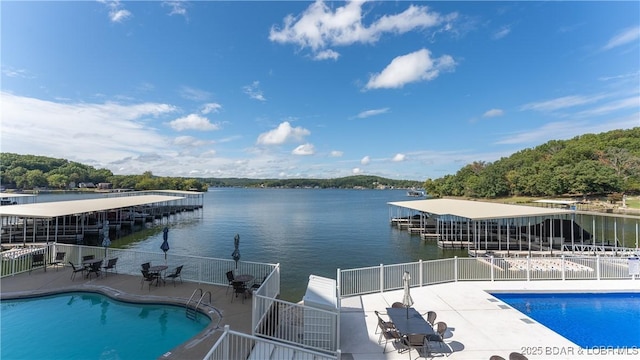 view of swimming pool with a patio area and a water view