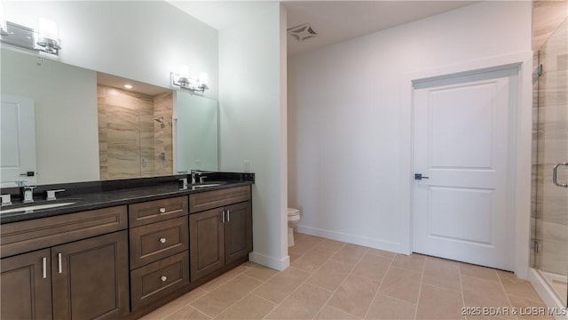 bathroom featuring vanity, an enclosed shower, tile patterned flooring, and toilet