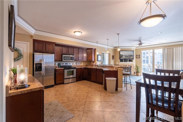 kitchen featuring stainless steel appliances, a kitchen breakfast bar, kitchen peninsula, decorative light fixtures, and ornamental molding