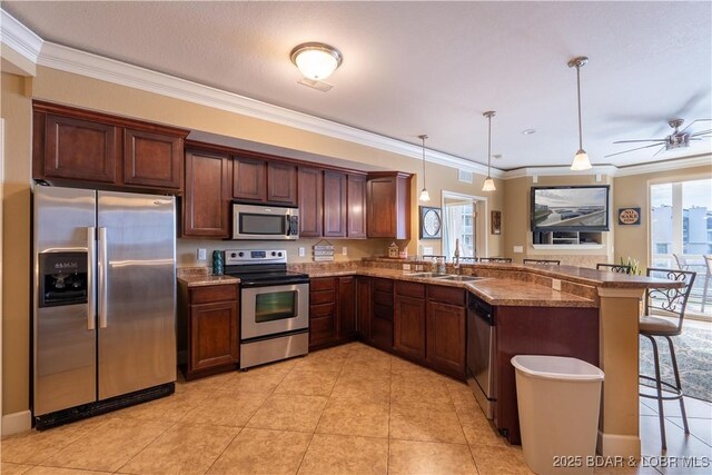 kitchen with sink, hanging light fixtures, kitchen peninsula, a breakfast bar area, and appliances with stainless steel finishes