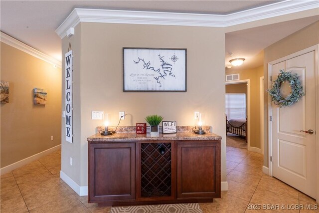 hall featuring ornamental molding and light tile patterned floors