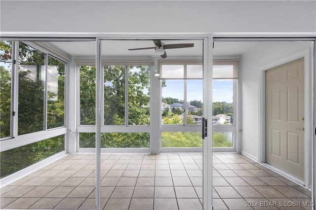 unfurnished sunroom with ceiling fan